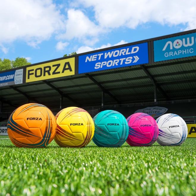 The 5x colours of FORZA training footballs on display on a pitch.