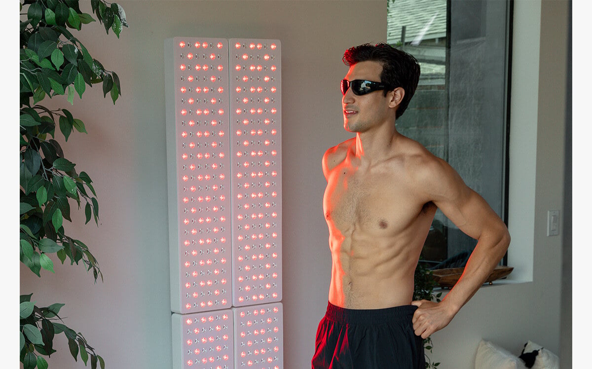 Man standing in front of a Joovv Quad 3.0 red light therapy device