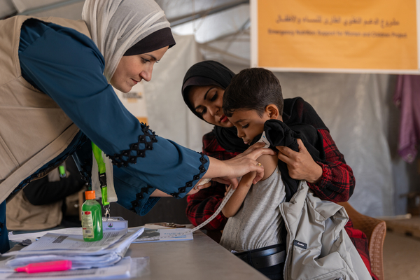 Yafa measures Jamil's arm with MUAC tape