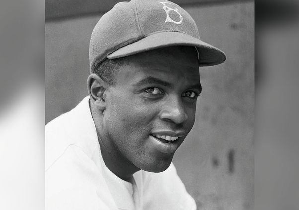 Black-and white head-and-shoulders portrait of Jackie Robinson in Brooklyn Dodgers cap
