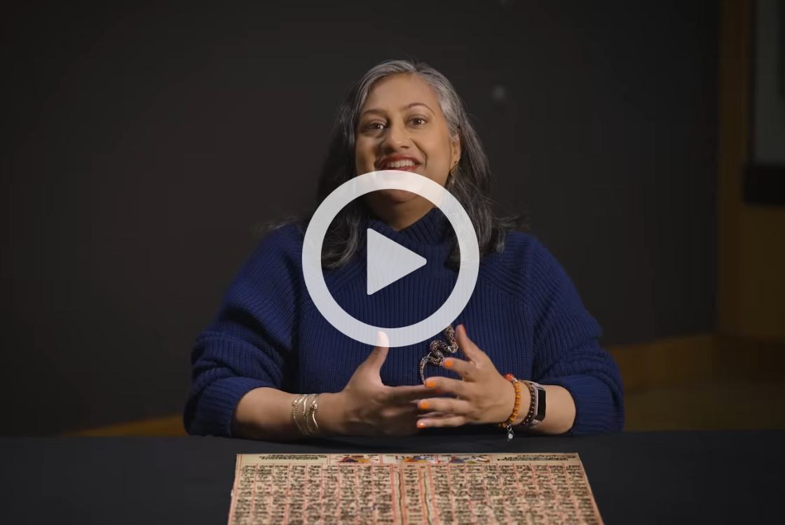 Curator sat with Moksha Patam game board.