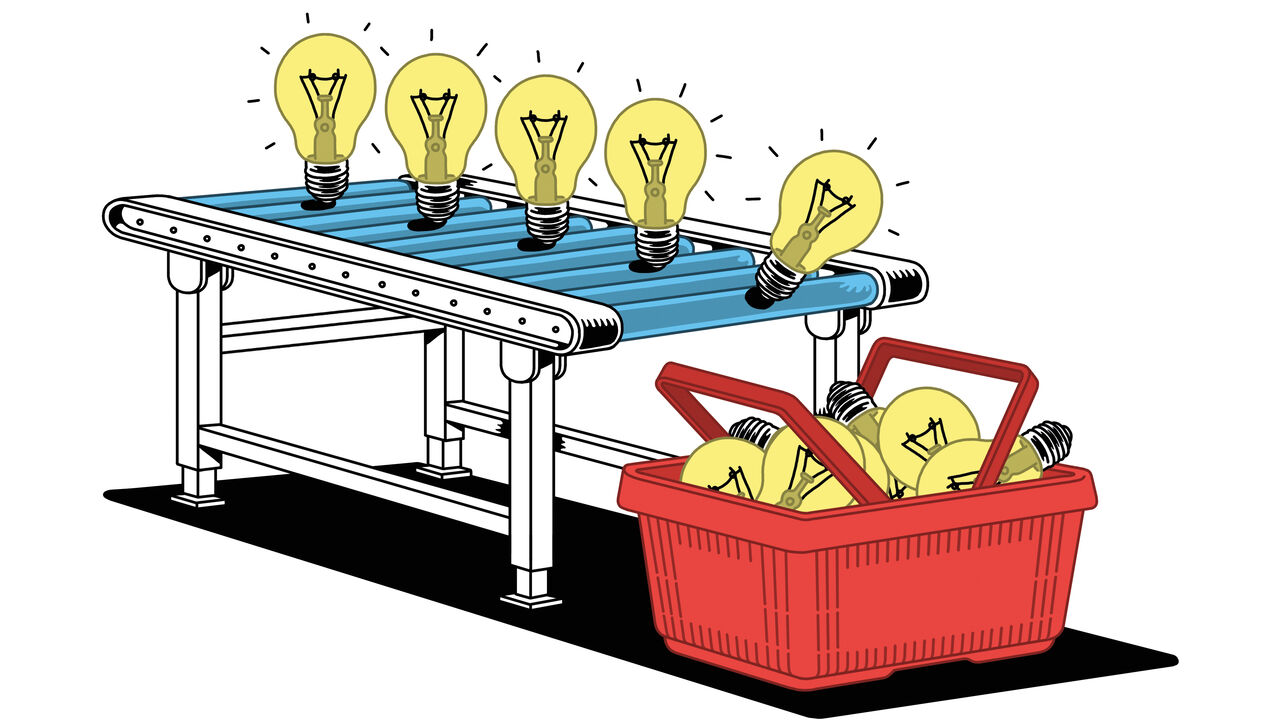 A conveyor belt with lightbulbs rolling on it and falling into a shopping basket. 