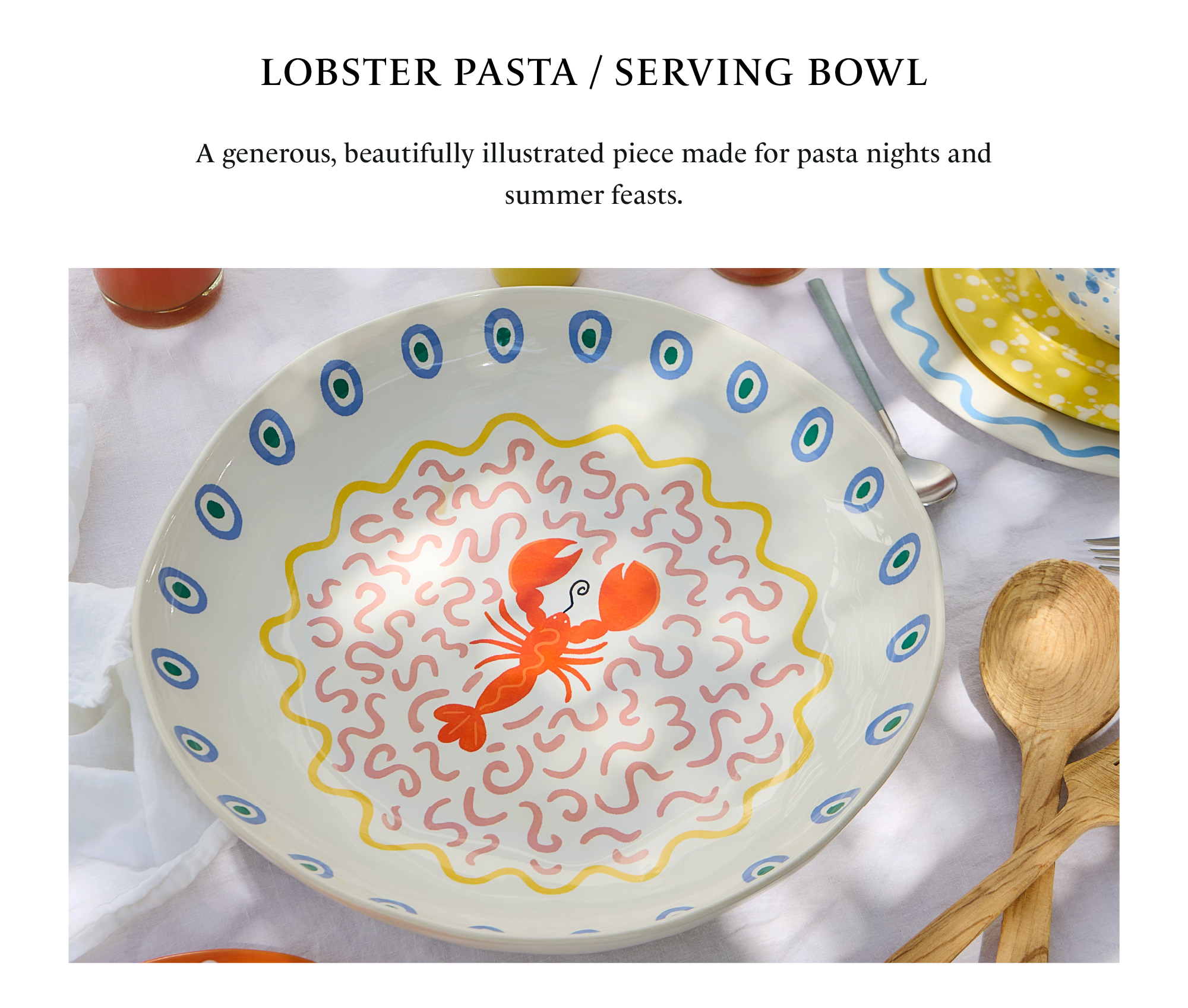 Lobster Pasta/Serving Bowl from the Summer Bliss collection, in white with a blue eye pattern on the rim and an orange lobster illustrated in the centre, on a table with wooden cutlery
