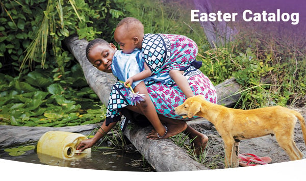 A young mother carries her son on her back as she collects water from a stagnant pond with a jerrycan. 
