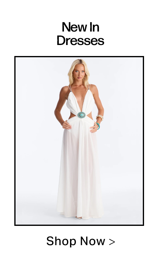 Elegant woman in a new white maxi dress featuring a plunging V-neck, waist cutouts, and a turquoise medallion. Shop our latest collection of dresses.