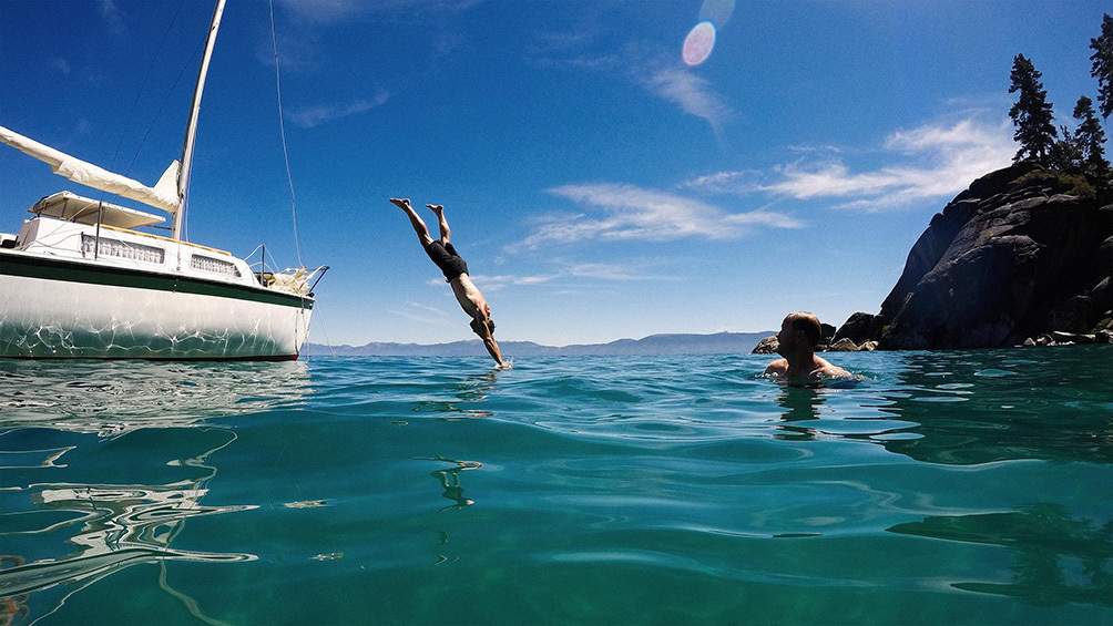 Image description: Man jumping off a boat into Lake Tahoe, California.
