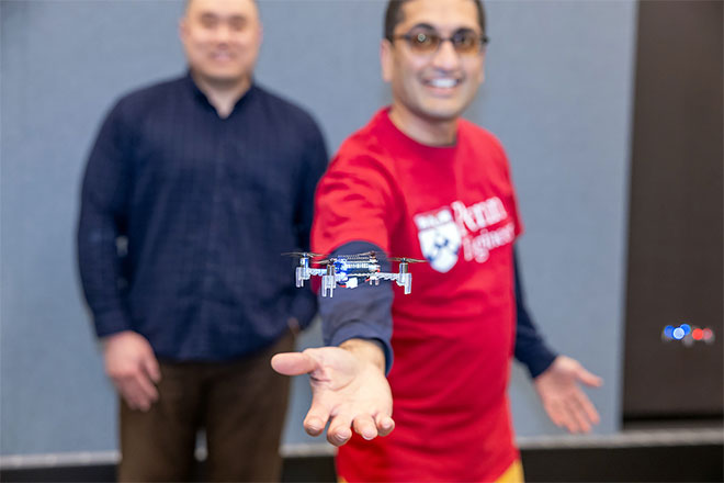 A drone hovers above Rahul Mangharam's hand.