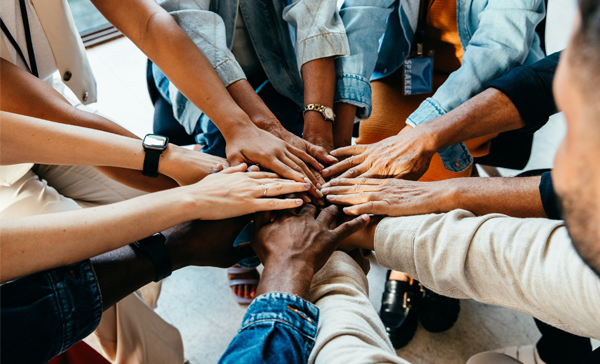  A group of people put their hands together in a circle
