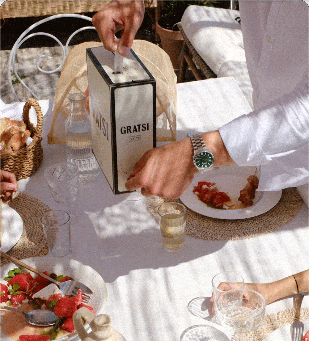 Animated GIF of man pouring Gratsi White Wine at an outdoor dinner table.