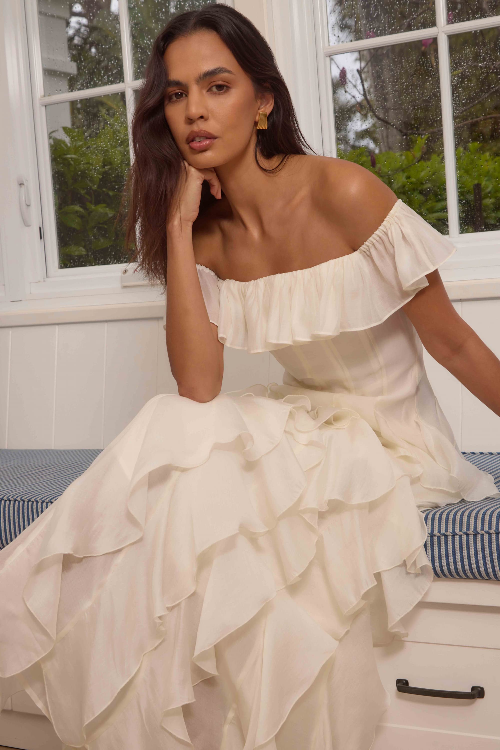 an image of a woman standing on a porch in a yellow dress