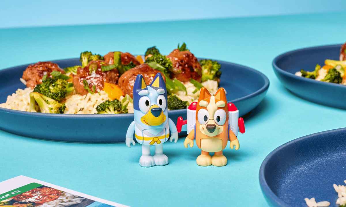 Image of a plate of food, with Bluey and Bingo next to it