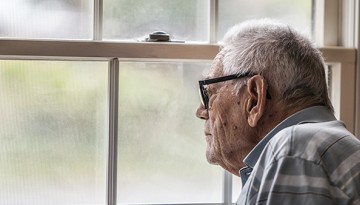 Older man staring out window