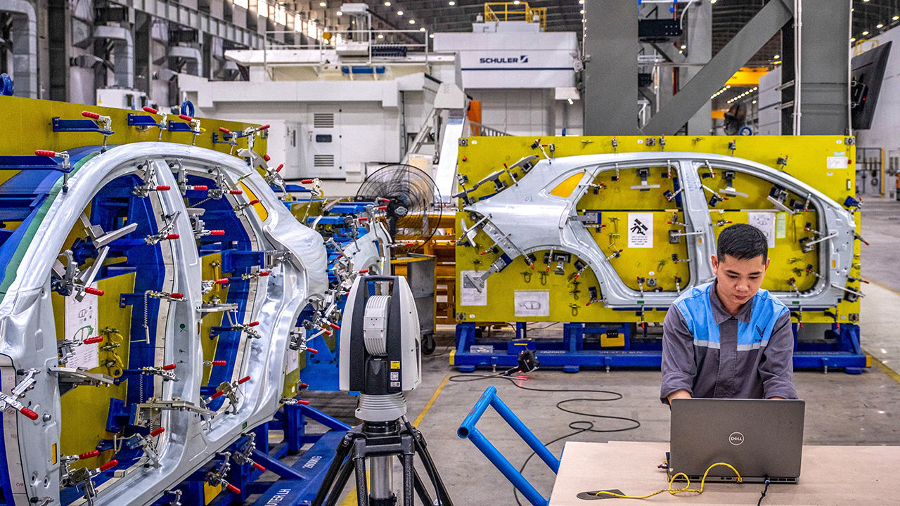 A worker inspects a vehicle body side panel at VinFast Auto manufacturing plant in Hai Phong, Vietnam