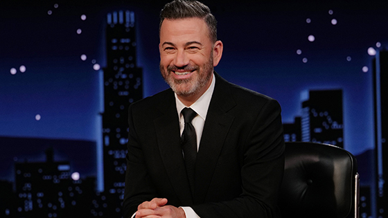 Jimmy Kimmel sits at his desk on the set of his TV show.