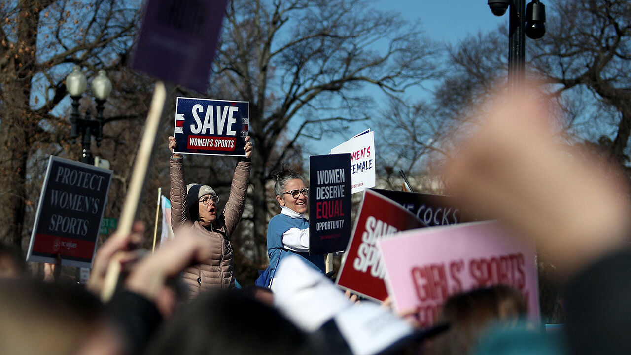 Protestors hold signs saying Save Womens Sport outside the Supreme Court in Washington DC