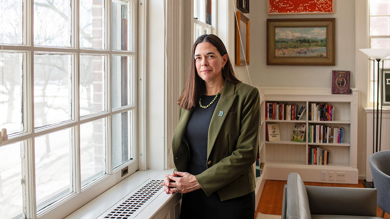 Portrait of Sian Leah Beilock, president of Dartmouth College, inside the school standing by a window.