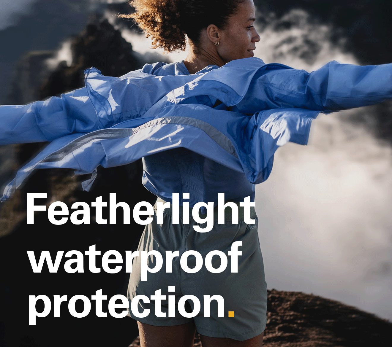 'Featherlight waterproof protection' text of the image of a women at the top of the mountains, in the clouds, wearing a Rab Phantom jacket.