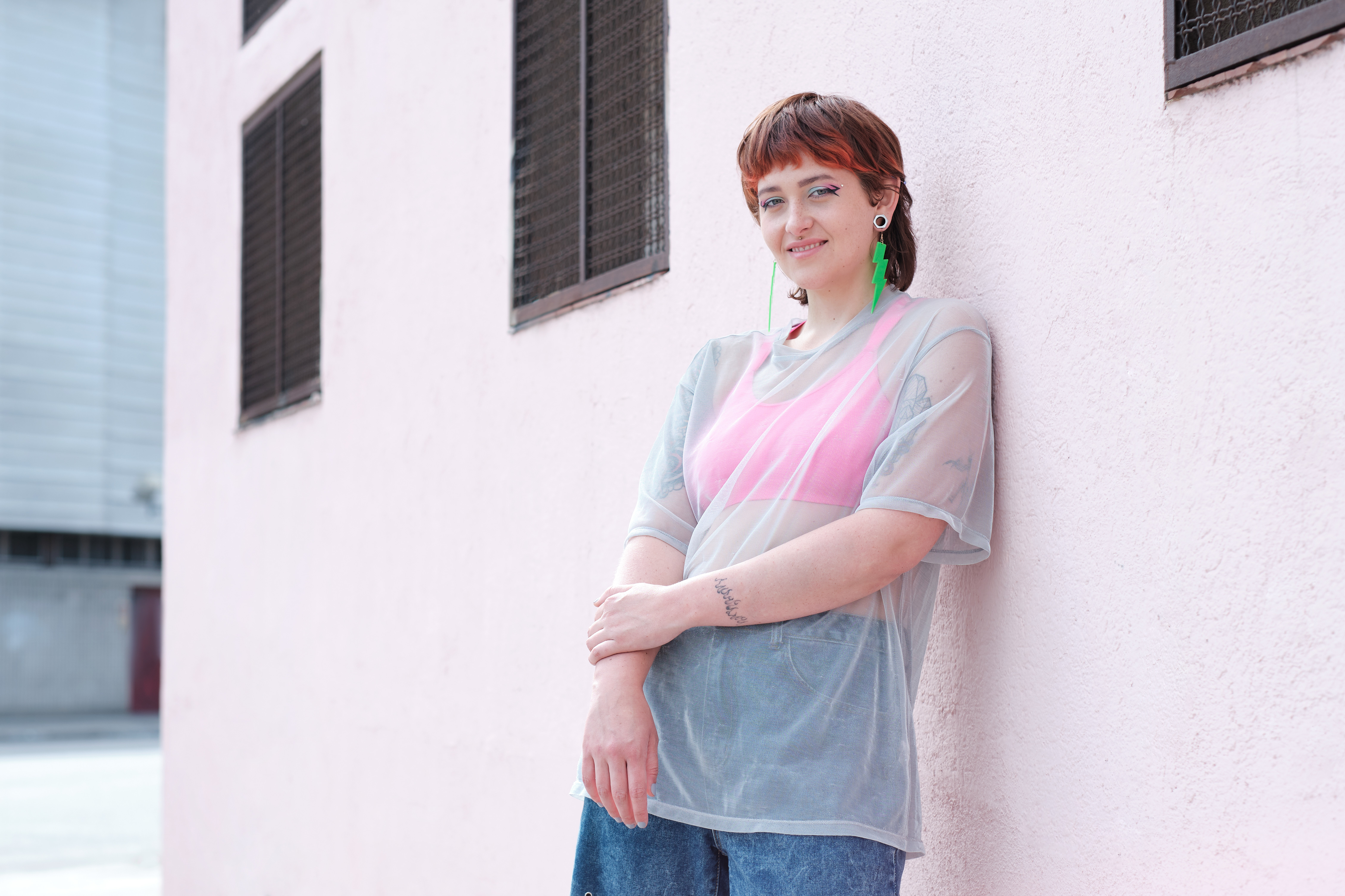 Ella smiling at the camera while leaning against a wall
