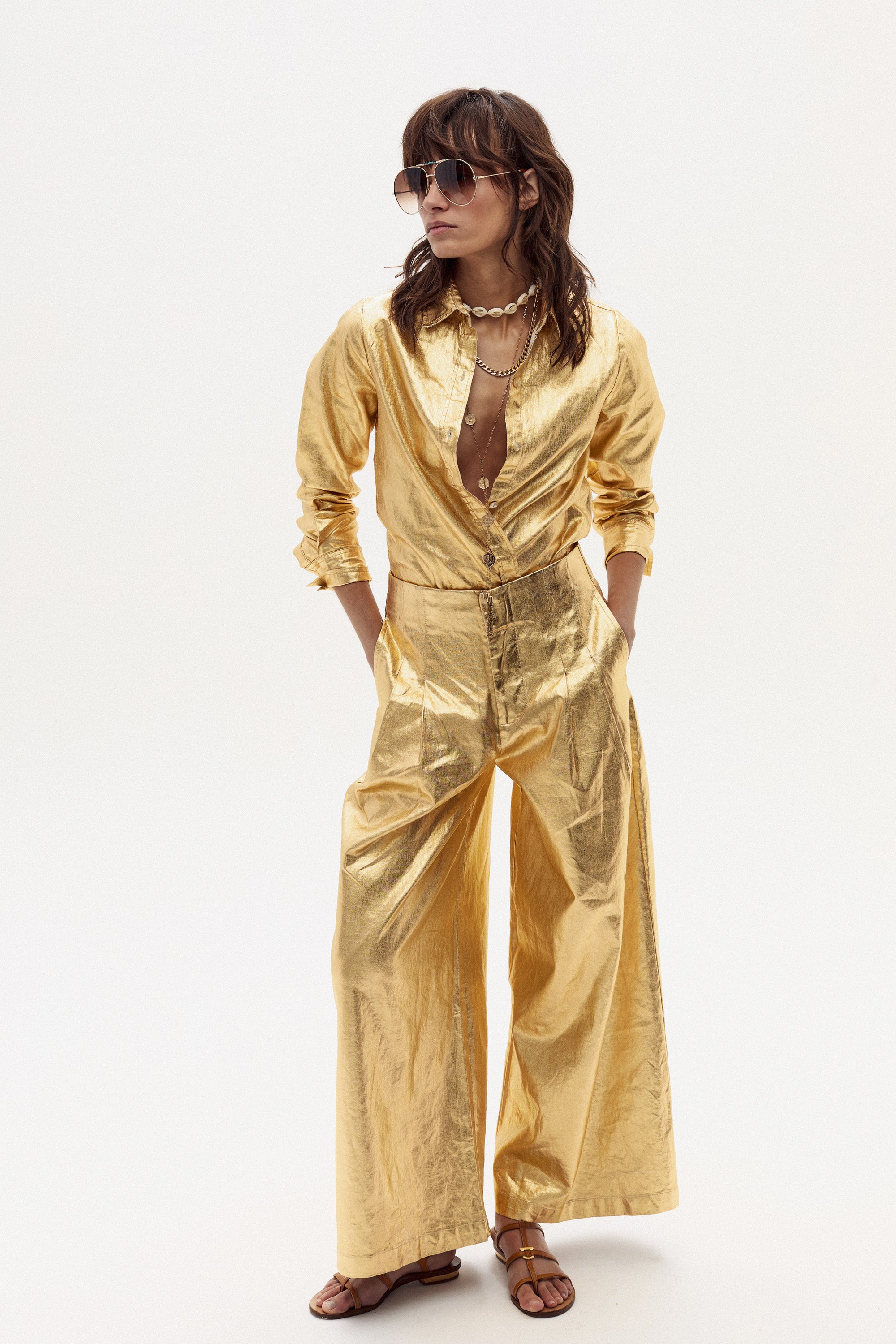 a woman in a gold dress and sunglasses