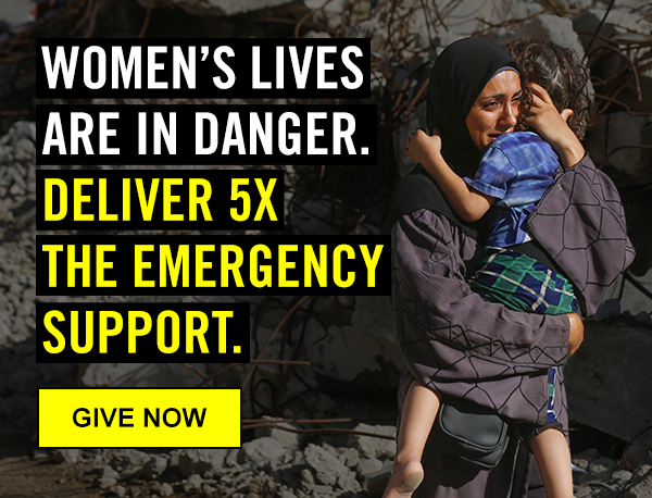 A Palestinian mother clinging to their child in a crisis zone, surrounded by rubble, with text 'WOMEN'S LIVES ARE IN DANGER. DELIVER 5X THE EMERGENCY SUPPORT.| GIVE NOW'