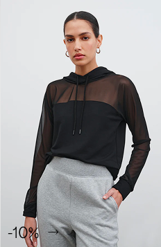 Astrid in The Park Sheer Hoodie with sheer sleeves paired with gray joggers.