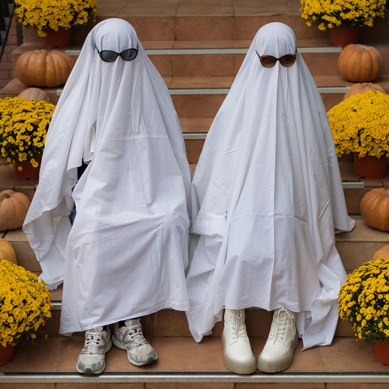 A couple dressed as ghosts for halloween. 