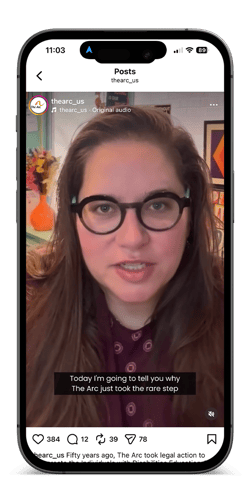A smartphone screen shows an Instagram post from thearc_us. A woman with long brown hair and black glasses speaks directly to the camera indoors. On-screen caption text reads, “Today I’m going to tell you why The Arc just took the rare step.” The Instagram interface, including likes, comments, and share icons, is visible at the bottom.