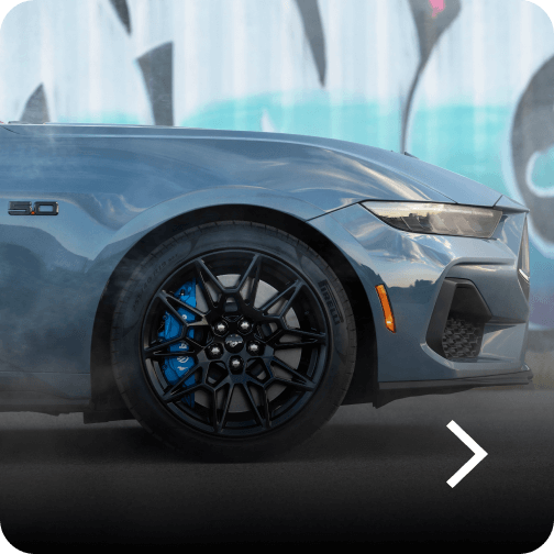 The front wheel and fender of a blue Ford Mustang® GT Fastback model