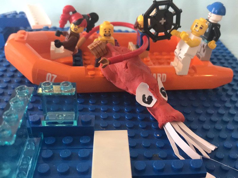 A LEGO lifeboat captures a colossal squid made from clay