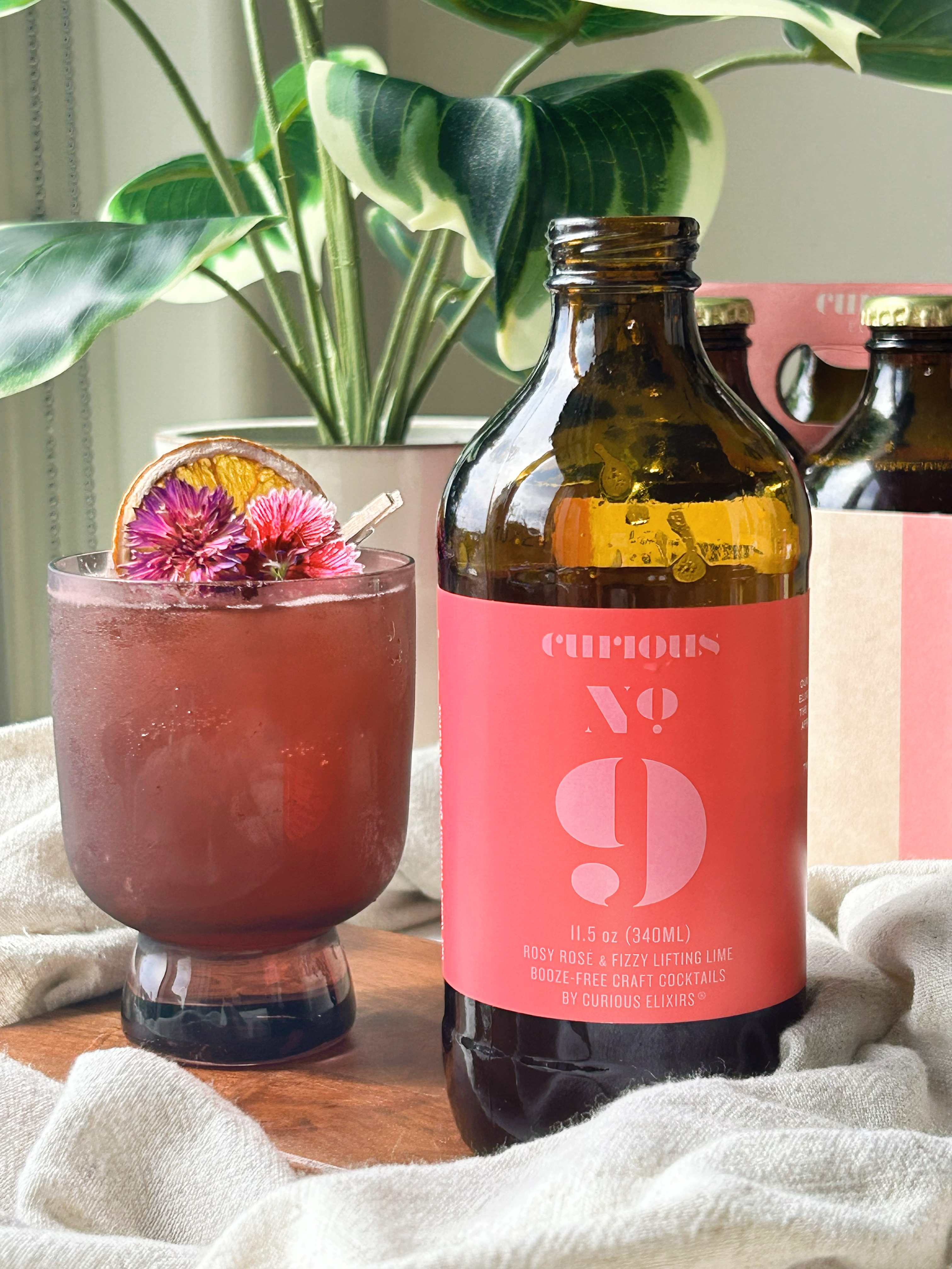 Curious No. 9 poured in a glass with dried flower garnishes