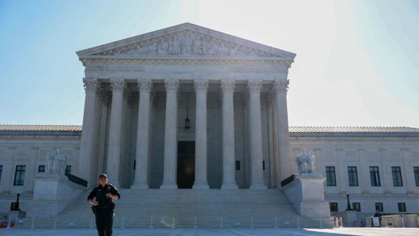 A law enforcement officer standing outside of the U.S. Supreme Court.
