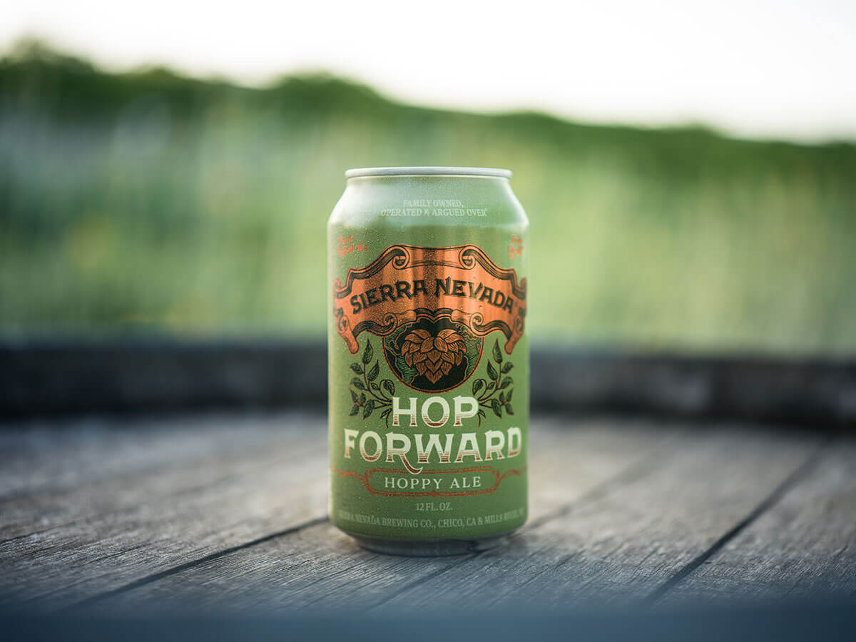 A can of Hop Forward outdoors on top of a wooden barrel