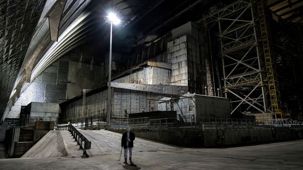 A worker measuring radiation contamination levels inside the new safe confinement sarcophagus at the Chernobyl nuclear power plant.