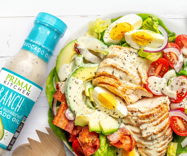 Primal Kitchen Ranch Dressing pouring on a colorful salad