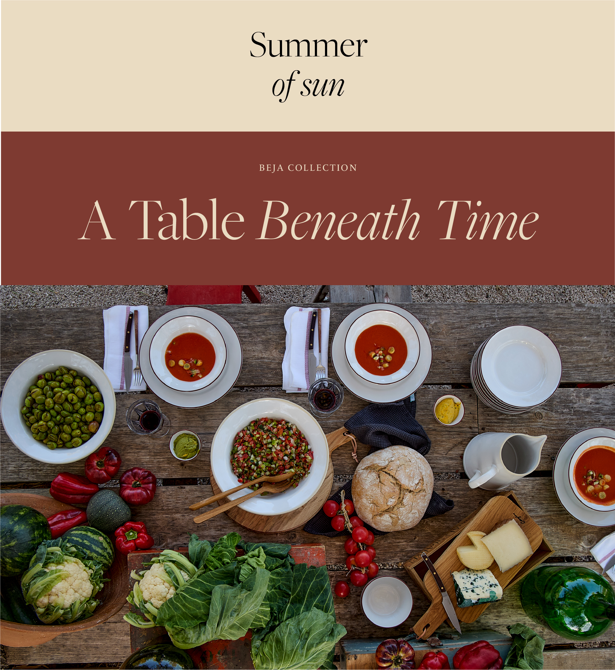 Summer of Sun cover, Beja collection. Rustic wooden table seen from above, set with white Beja soup plates with a red rim and gazpacho, a bowl of olives, bread, tomatoes, peppers, cabbages and cheese