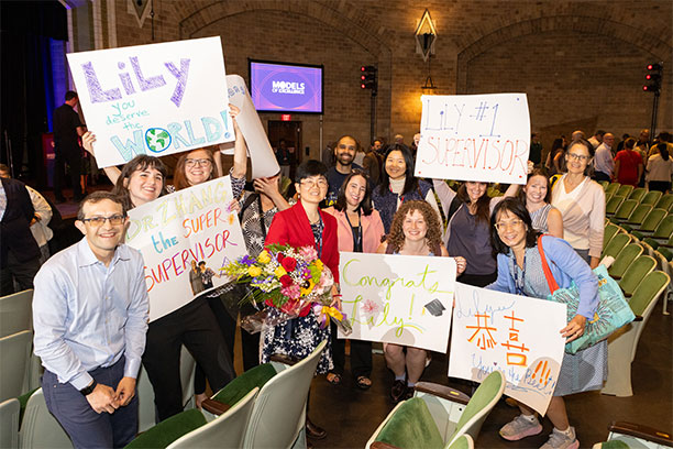 Penn staff hold posters at the Models of Excellence ceremony.