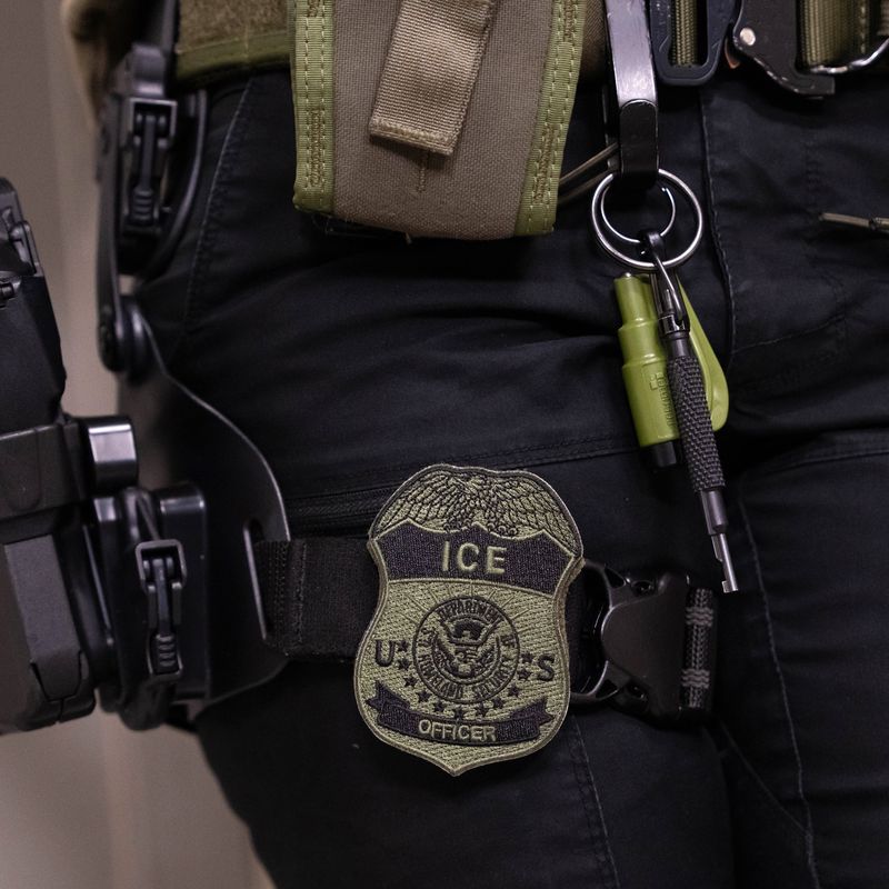 Close up of ICE Agent's badge and weapon.