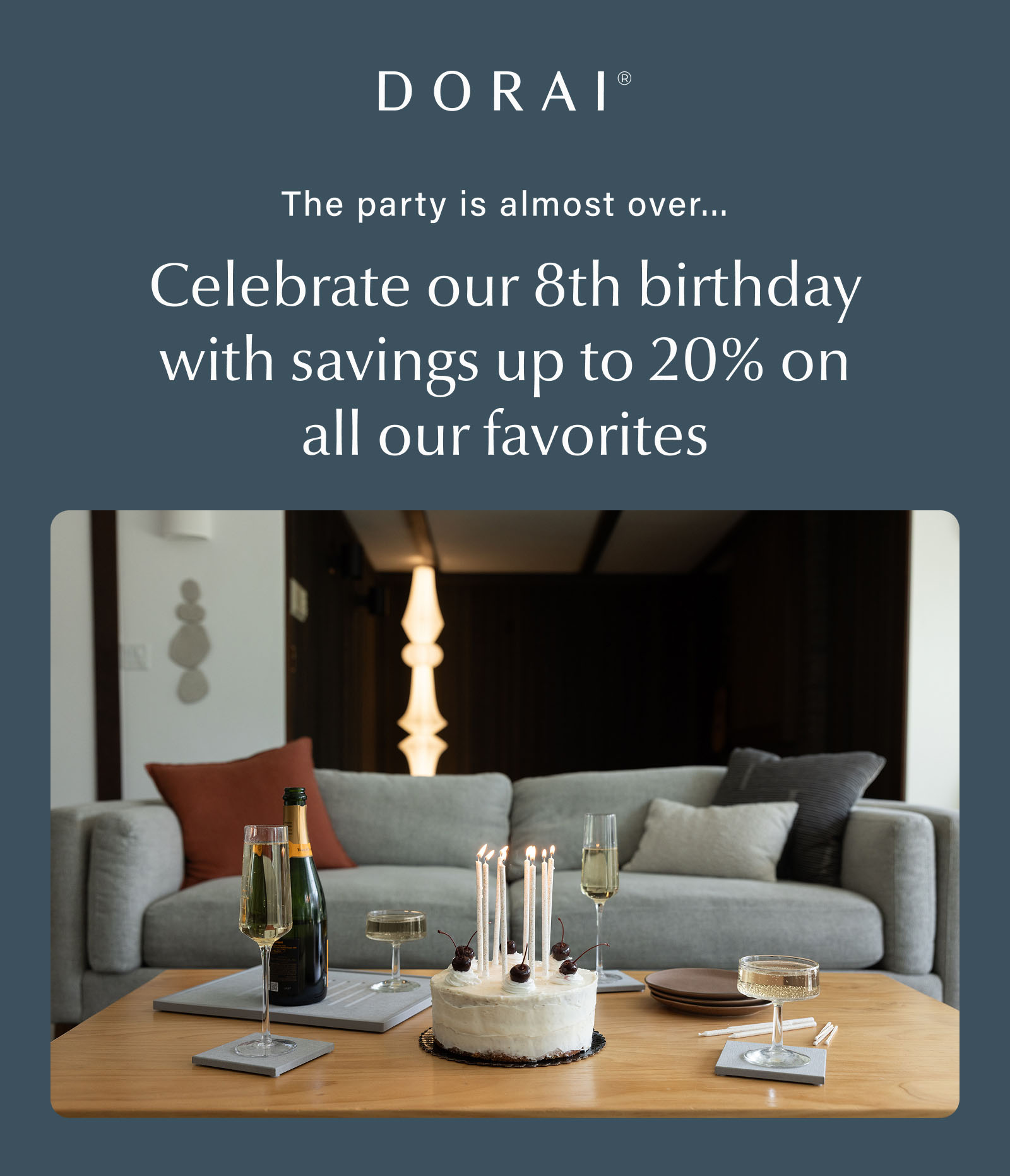Birthday cake with lit candles on a coffee table surrounded by Dorai stone coasters and glasses of sparkling wine and a champagne bottle. Text reads: "The party is almost over... Celebrate our 8th birthday with savings up to 20% on all our favorites."
