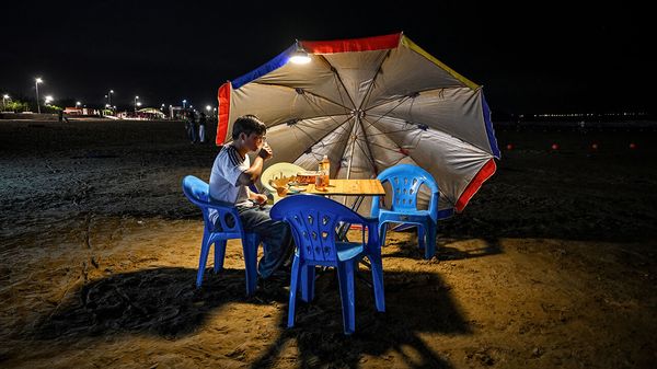 A man relishes food and drinks at a beach in Pingtan island, the closest point in China to Taiwan's main island, in Fujian province on May 19, 2024.