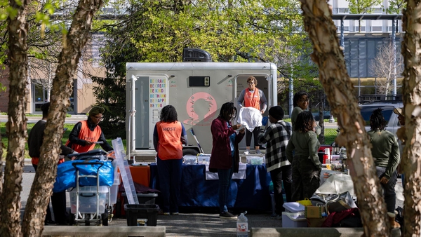 volunteers hand out clothes, food and toiletries, with two-stall mobile shower trailer in background