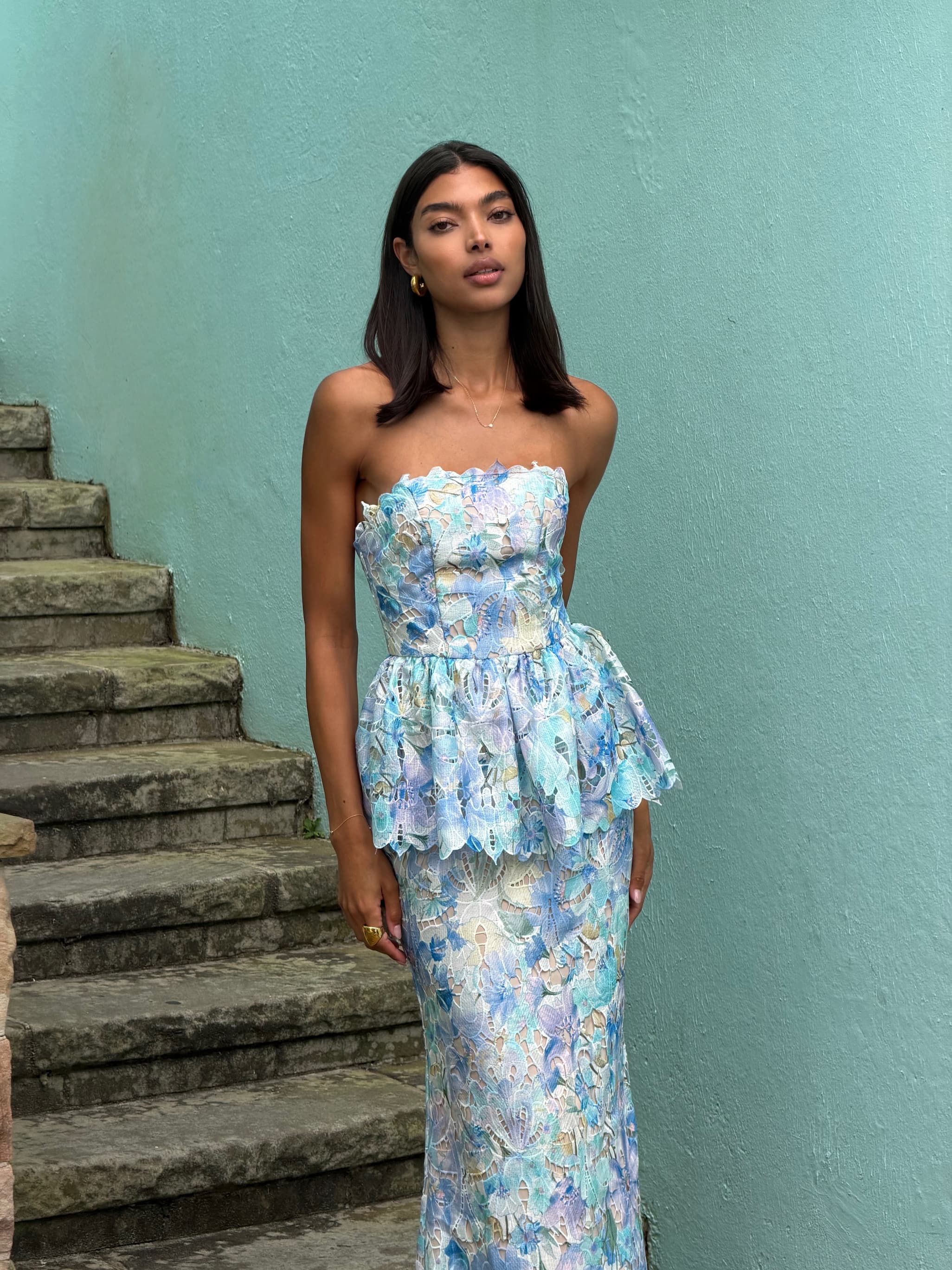 an image of a woman standing on a porch in a yellow dress