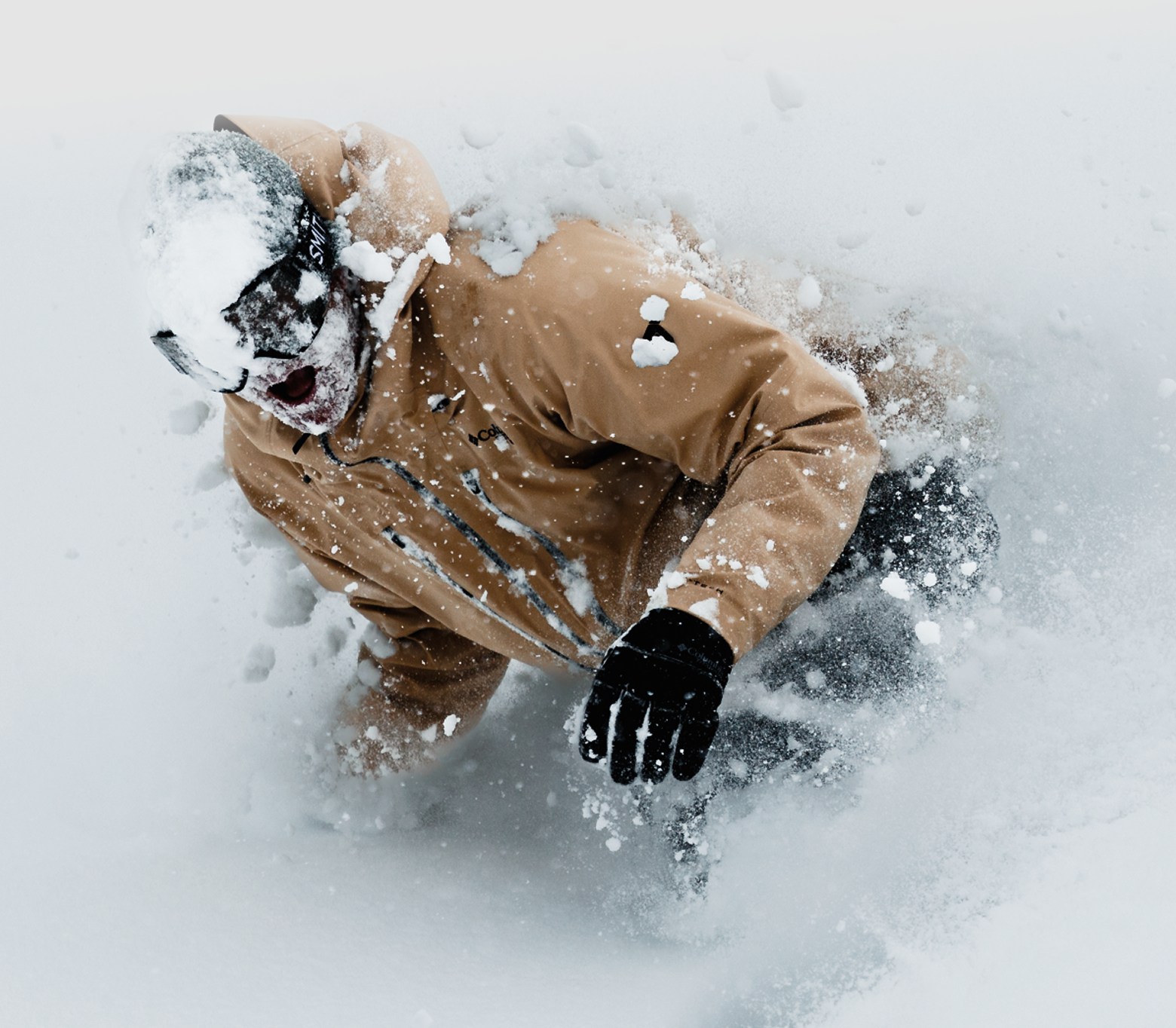 A snowboarder slashing through snow in Columbia gear