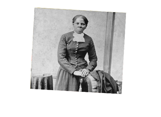 Harriet Tubman poses next to a sofa.