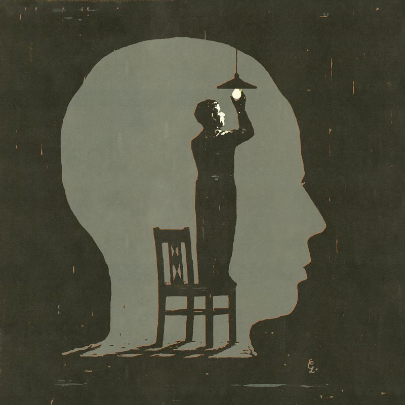 A figure changing a light inside the silhouette of a head.