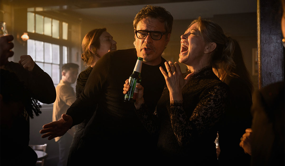 A man and a woman sing in a bar together.