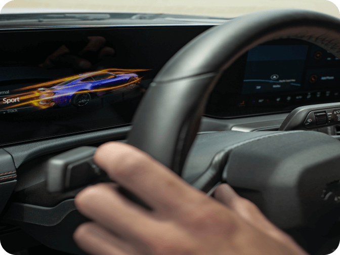Close‑up of hands on the steering wheel of Ford Mustang&reg; model with dashboard showing Sport mode enabled