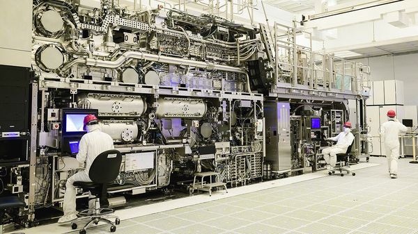 Workers are seen in front of a High NA EUV lithography system at an Intel facility in Hillsboro, Oregon, U.S.