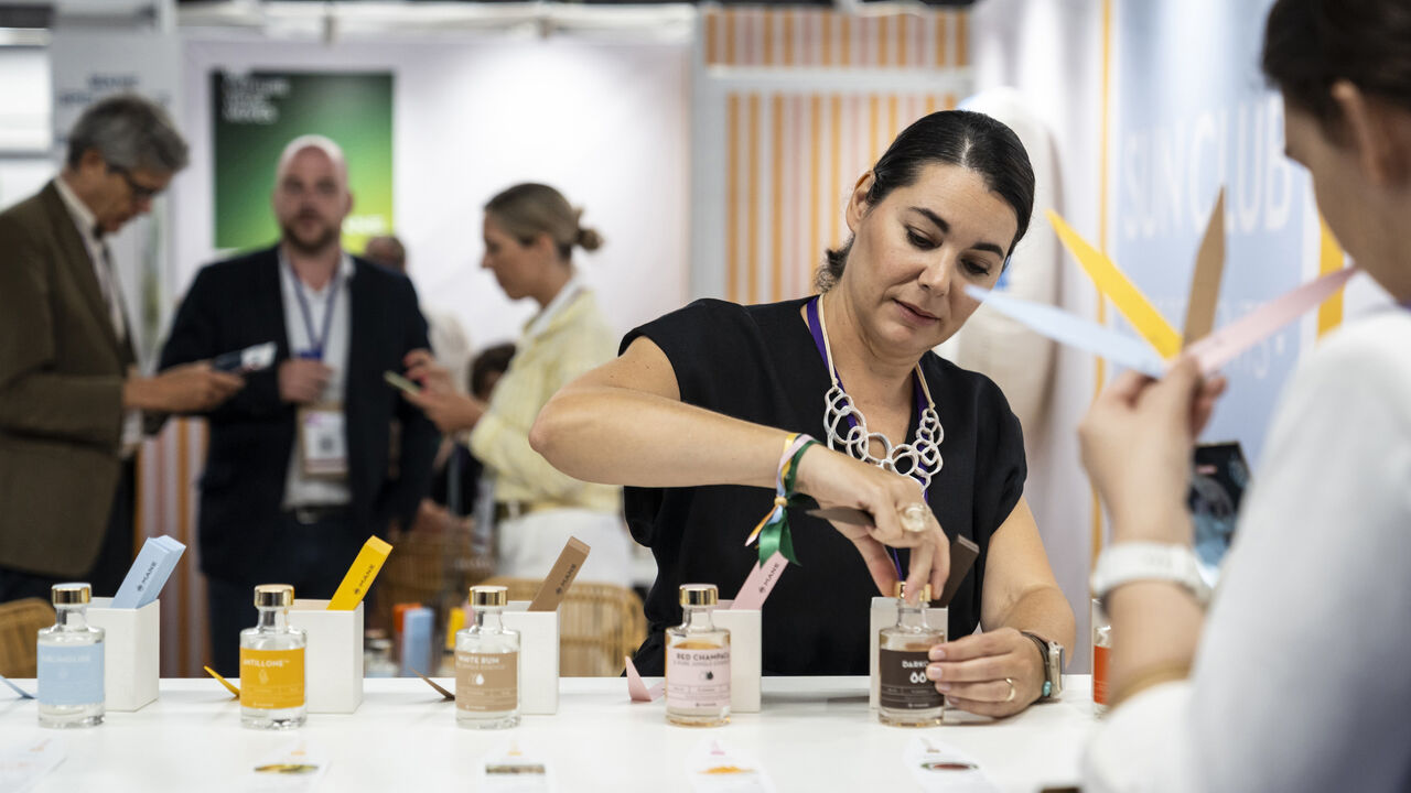 Customers at a perfume counter smelling samples.