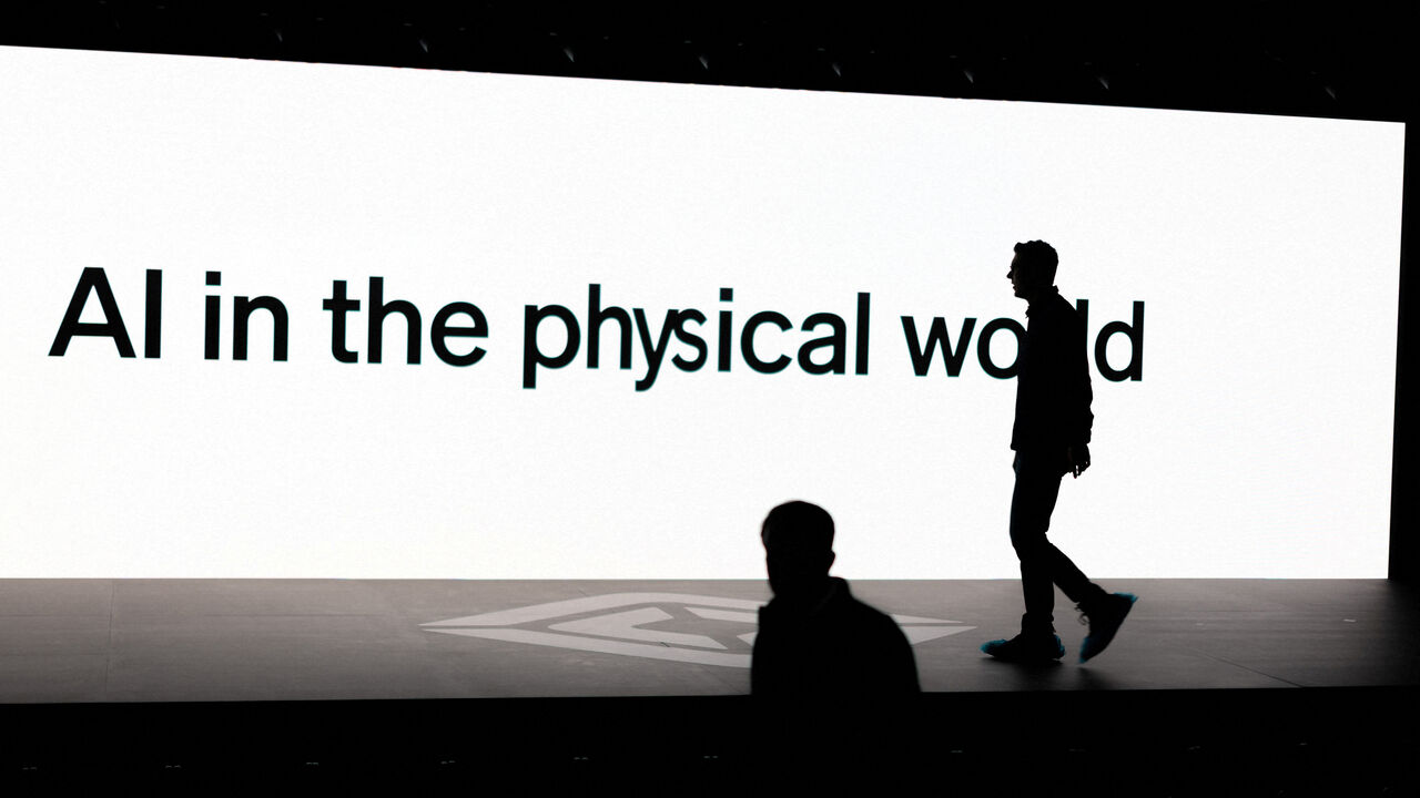 A screen reads 'AI in the physical world' as attendees gather during Rivian's first Autonomy and AI (artificial intelligence) Day in California, USA.