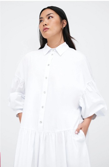 Shannon models the Ada Dress with puffed sleeves and a gathered skirt, looking off-camera.